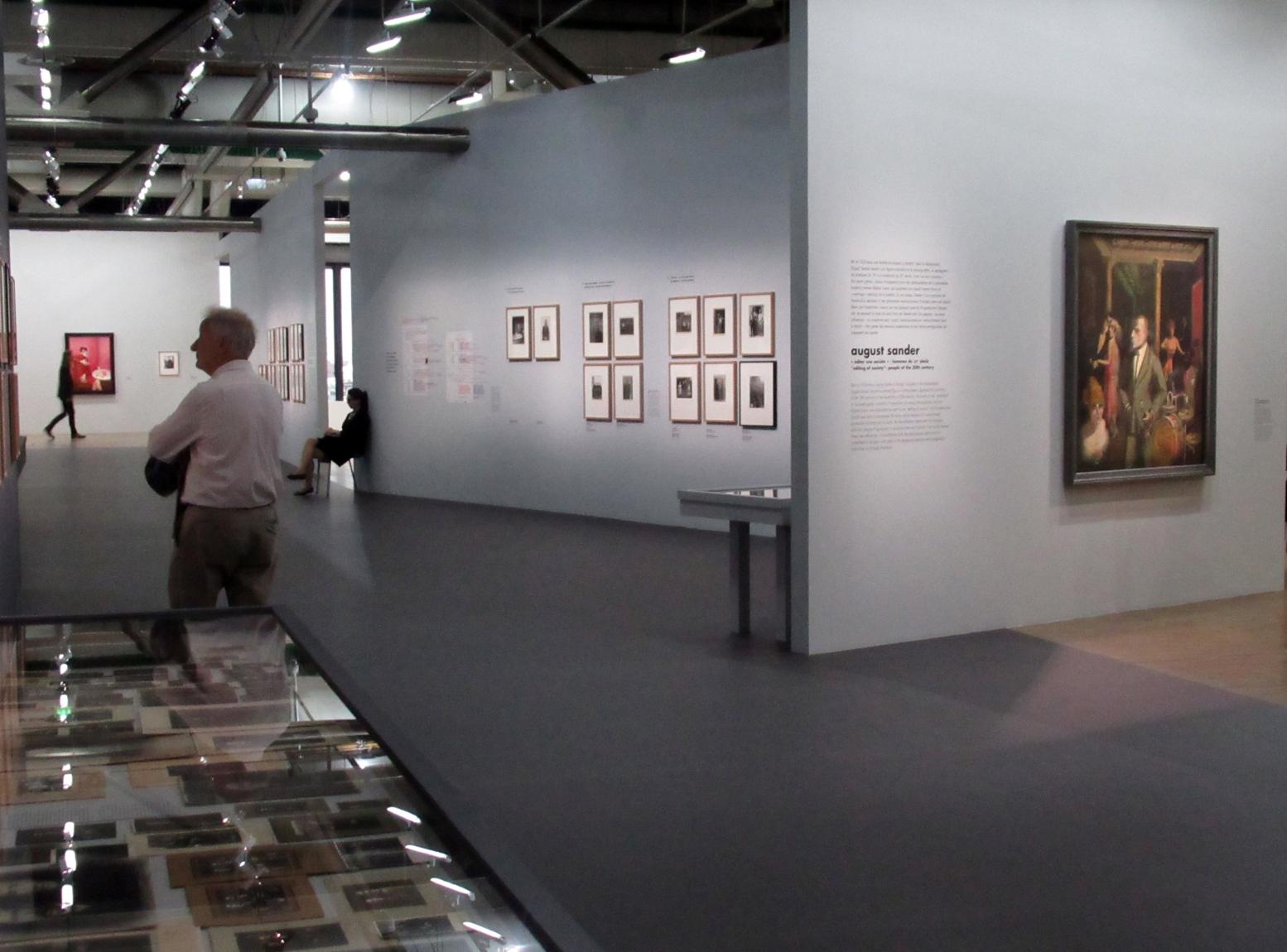 Besucher gehen durch die Werkschau "Deutschland / 1920er Jahre / Neue Sachlichkeit / August Sander". Rechts hängt das Gemälde "An die Schönheit", ein Selbstbildnis von Otto Dix aus dem Jahr 1922