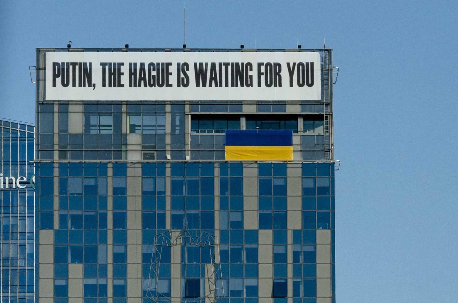 Ein Banner an einem Gebäude im Zentrum von Vilnius mit der Aufschrift „Putin, Den Haag wartet auf Sie“