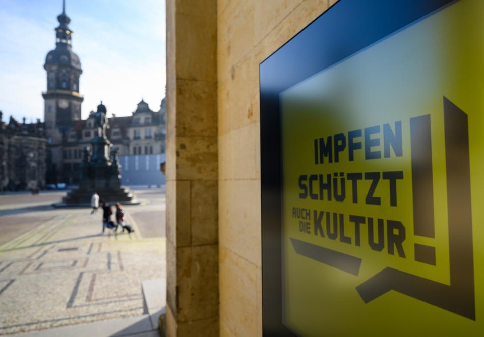 Schild mit der Aufschrift "Impfen schützt auch die Kultur" vor der Semperoper in Dresden