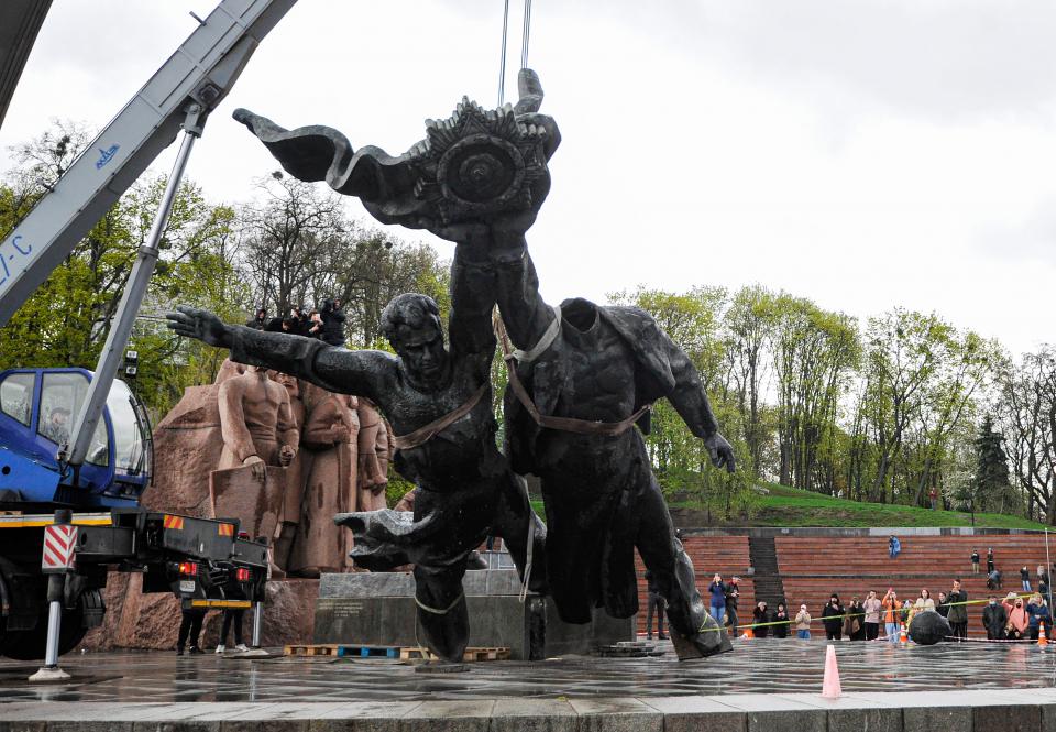 Arbeiter demontieren das sowjetische Denkmal der ukrainisch-russischen Freundschaft, das 1982 als Symbol für die Wiedervereinigung der Ukraine und Russlands inmitten des russischen Einmarsches in die Ukraine errichtet wurde
