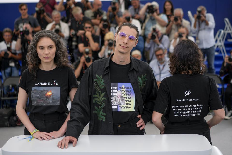 Der ukrainische Filmemacher Maksym Nakonechnyi mit den Produzentinnen Darya Bassel (l) und Yelizaveta Smith (r) protestieren auf dem 75. Filmfestival in Cannes