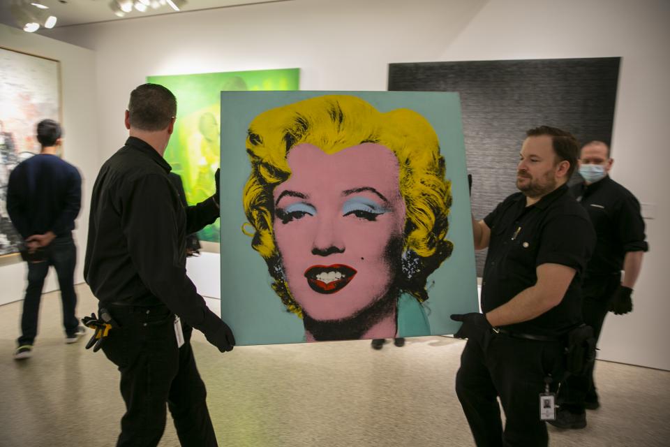 Das Gemälde "Shot Sage Blue Marilyn" von Andy Warhol aus dem Jahr 1964 wird in einen New Yorker Ausstellungsraum von Christie's getragen