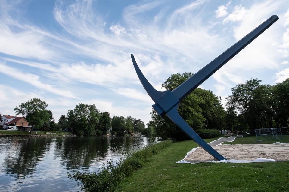 Ebenfalls 1982 platzierte Claes Oldenburg Die Spitzhacke am Ufer der Fulda nahe der Drahtbrücke. Das überdimensionierte Denkmal des Werkzeugs verweist auf Kassels Wiederaufbau. Nach Oldenburgs Worten hat der Herkules, der im Bergpark über Kassel thront, die Spitzhacke dorthin geschleudert