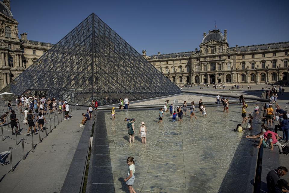 Menschen stehen im Brunnen vor dem Louvre in Paris. In ganz Europa ist der Sommer 2022 von überdurchschnittlichen Temperaturen und Hitzewellen geprägt. Das beschäftigt auch die Museen