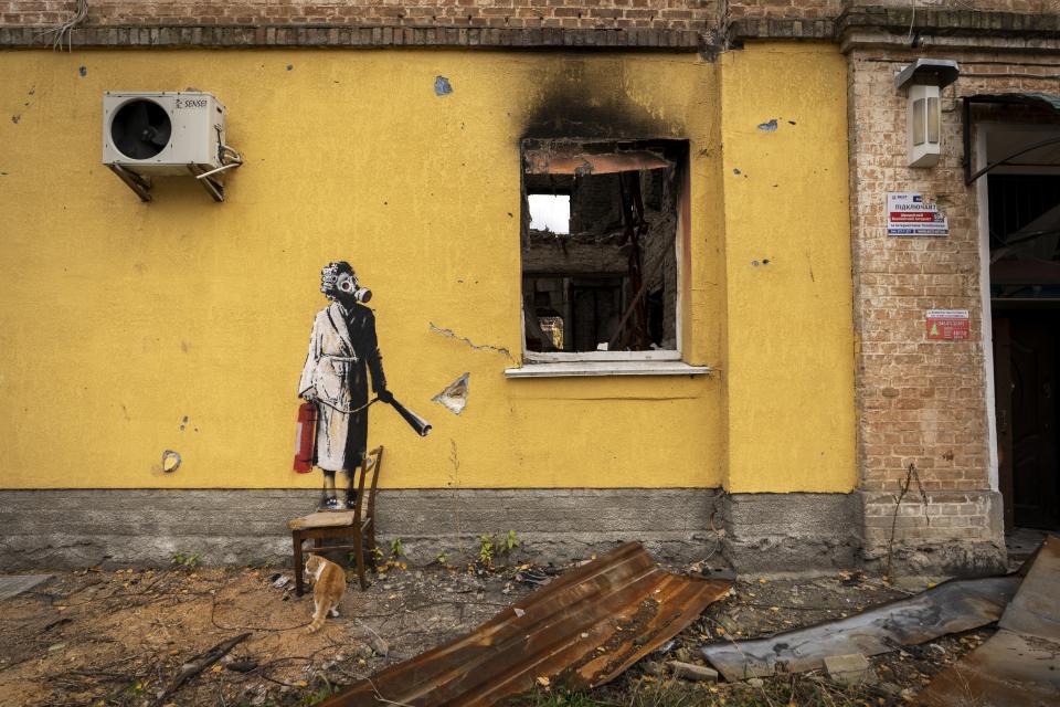 Das Foto, das der Streetart-Künstler Banksy auf seinem Instagram-Kanal veröffentlicht hat, zeigt ein kriegszerstörtes Haus. Auf der gelben Wand des Gebäudes ist eine Person zu sehen, die eine Gasmaske und einen Feuerlöscher trägt