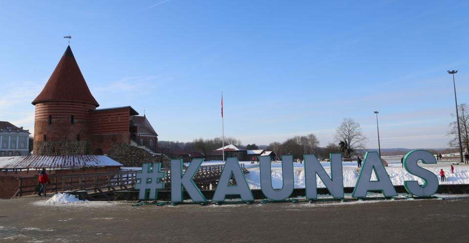 In großen Buchstaben steht der Schriftzug "Kaunas" vor der Burg