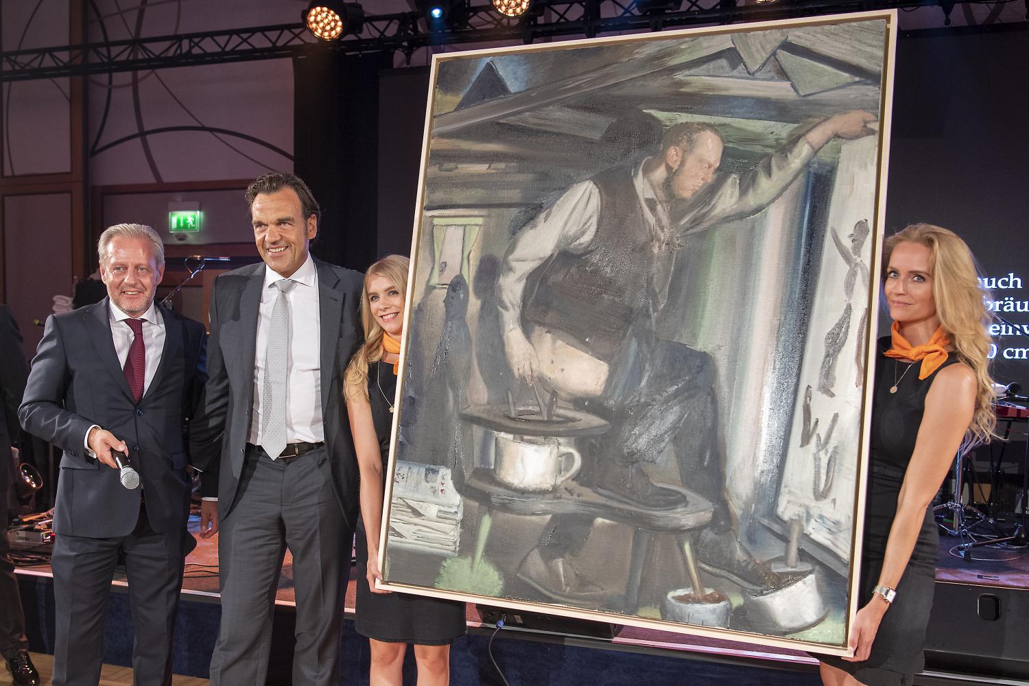 Auktions-Veranstalter Steffen Göpel (links) und Unternehmer Christoph Gröner (2.von links) neben dem Gemälde "Der Anbräuner". Das Bild wurde auf einer Charity Auktion in Leipzig versteigert