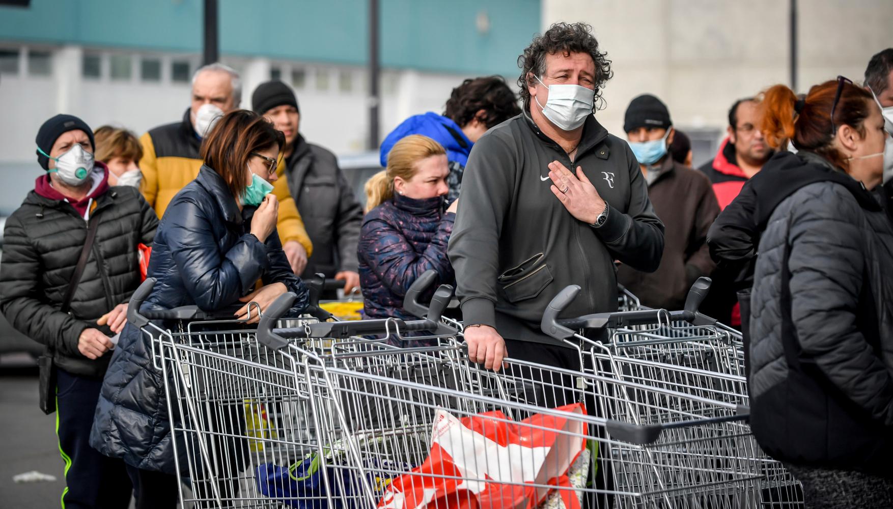 Menschen im italienischen Casalpusterlengo stehen vor einem Supermarkt in einer Schlange