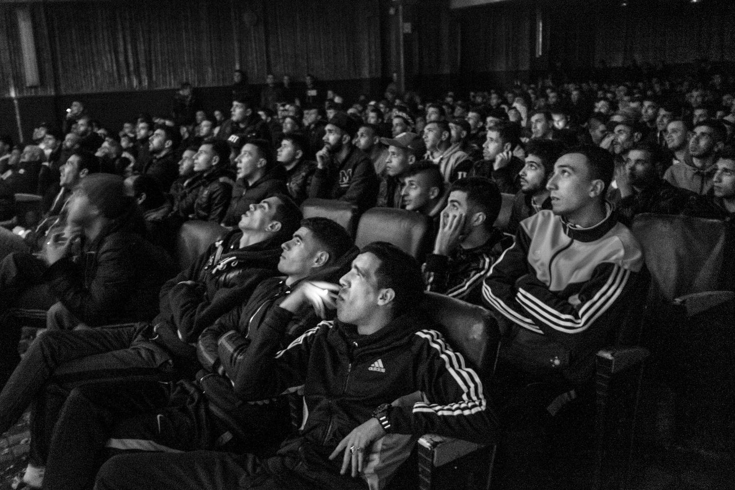 Jugendliche sehen ein Fußballspiel, das im Kino Olympia in Algier gezeigt wird. Das Kino überträgt mehrmals wöchentlich europäische Spiele