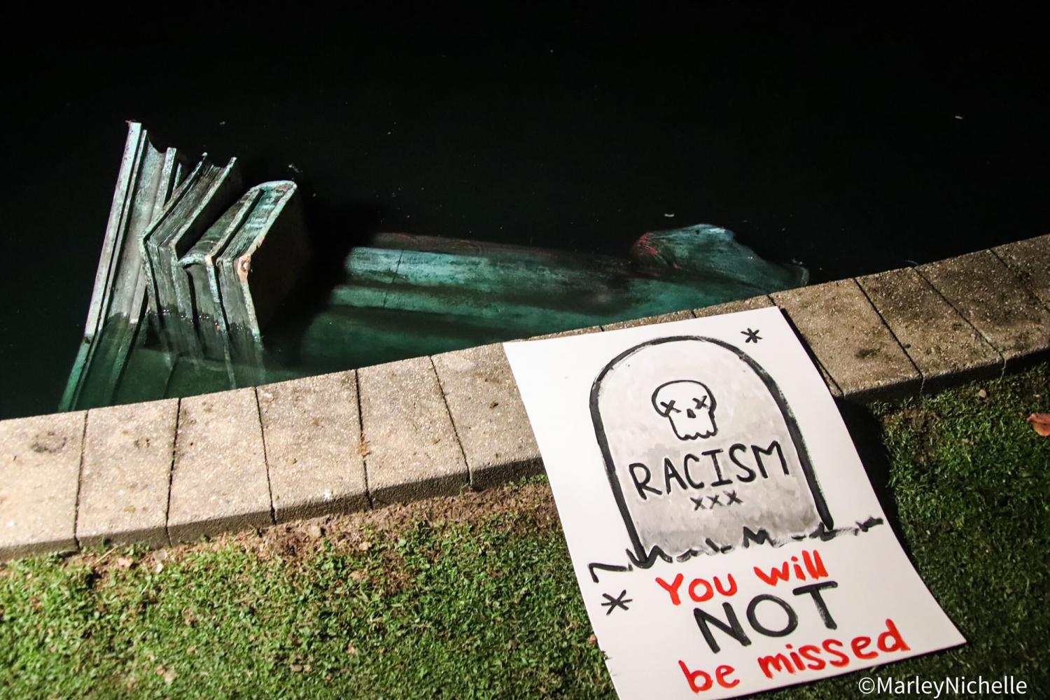 Plakat mit der Aufschrift "Rassismus - du wirst nicht vermisst" am Ufer des James-Flusses, in dem eine Statue von Christopher Columbus versenkt wurde
