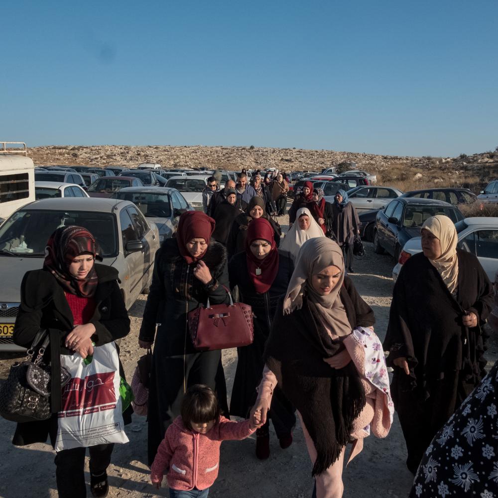 Einige der Ehefrauen, Mütter und Kinder von palästinensischen Gefangenen, erreichen am Tag des Gefängnisbesuchs den Checkpoint. Diese Familien müssen am Besuchstag eine weite Strecke von ihren Dörfern zum israelischen Gefängnis zurücklegen. Auf dem Weg dorthin ist die Unterstützung, die sich die Frauen gegenseitig geben, dringend notwendig, denn sonst wären sie nicht in der Lage wären, die unzähligen Schwierigkeiten zu bewältigen, denen sie auf dem Weg begegnen. Die Fotoreportage "H