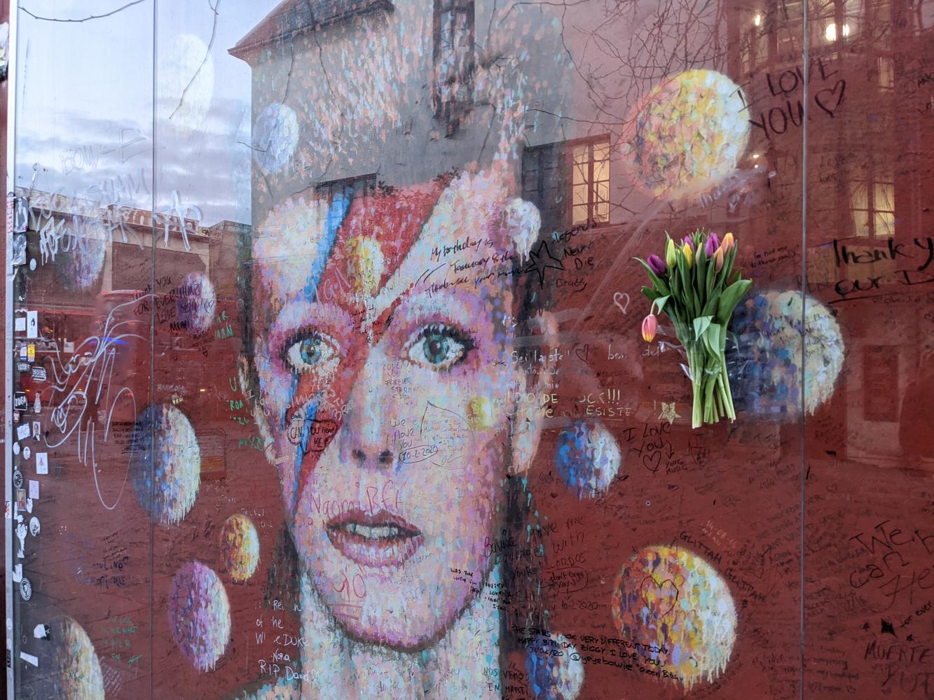 Blumen und Botschaften am David-Bowie-Denkmal des australischen Künstlers James Cochran (Jimmy C) im Stadtteil Brixton, London