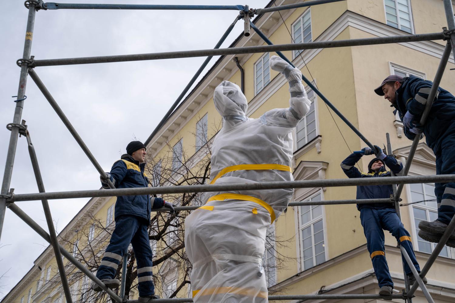 Arbeiter installieren Schutzvorrichtungen für eine Statue