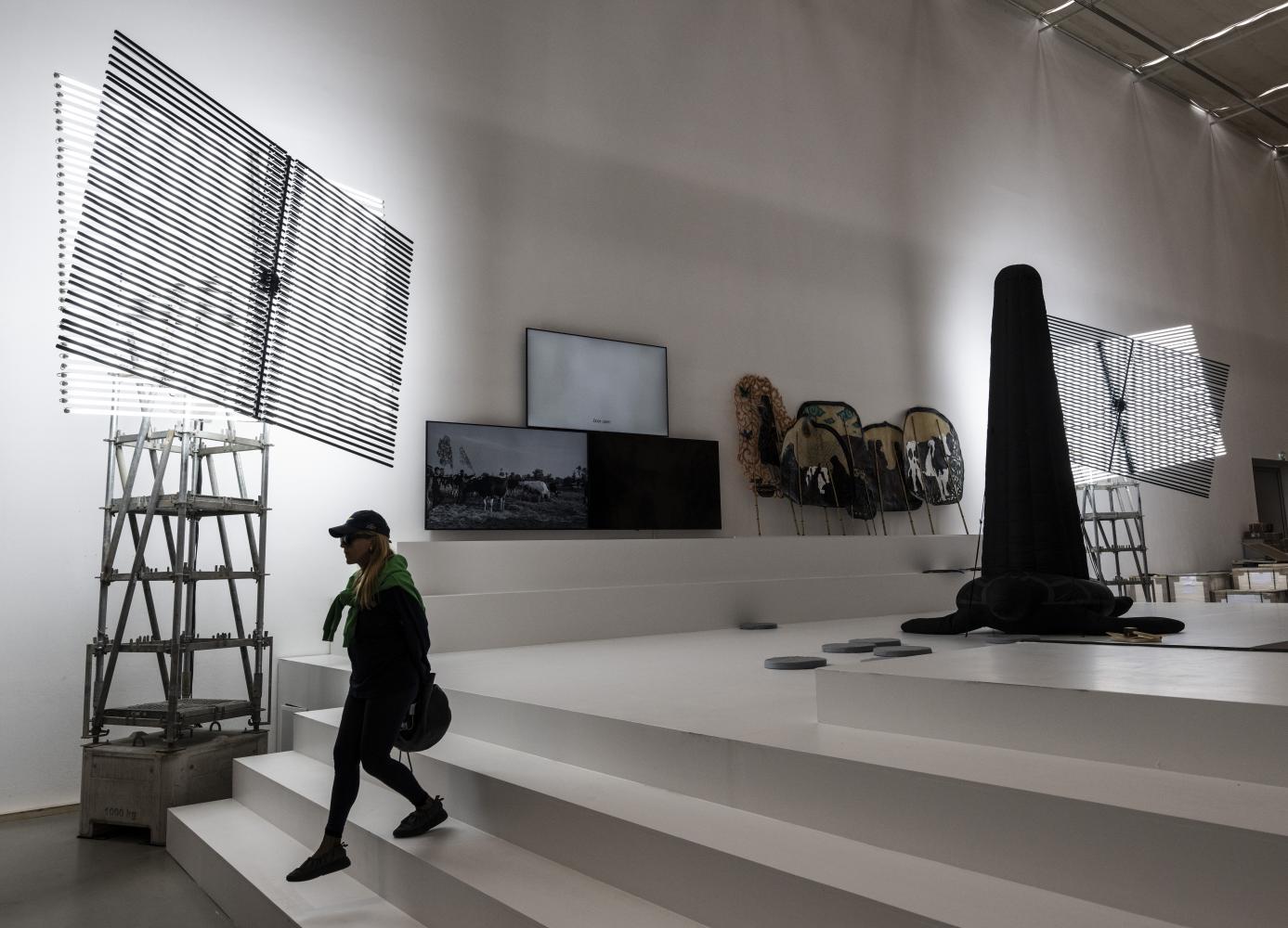 "Schattentheater" heißt eine Installation aus sich drehenden Leuchtstoffröhren, an der eine Besucherin der Documenta vorbeigeht