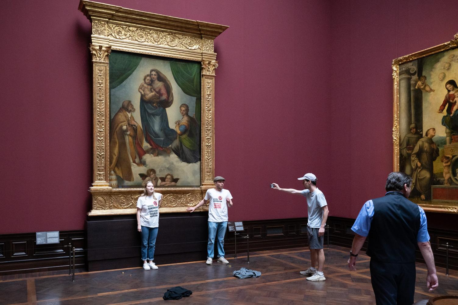 Umweltaktivisten der Gruppe "Letzte Generation" stehen in der Gemäldegalerie Alte Meister in Dresden an dem Gemälde "Sixtinische Madonna" von Raffael