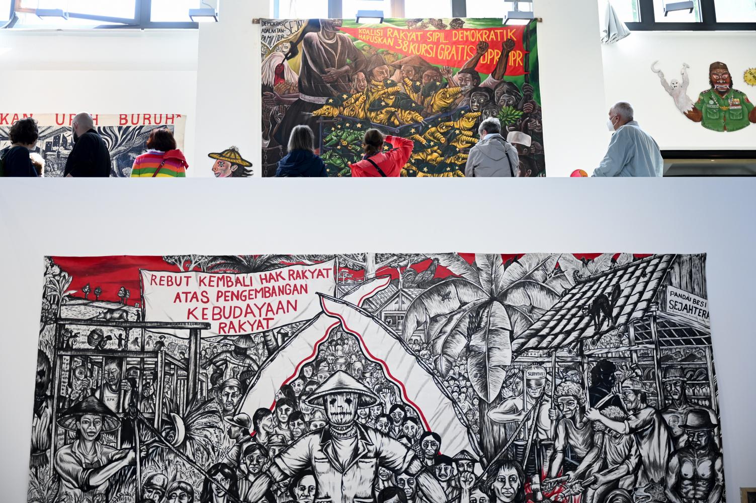 Besucher sehen sich im Kasseler Hallenbad-Ost die Agitprop-Kunst des indonesischen Künstlerkollektivs Taring Padi an