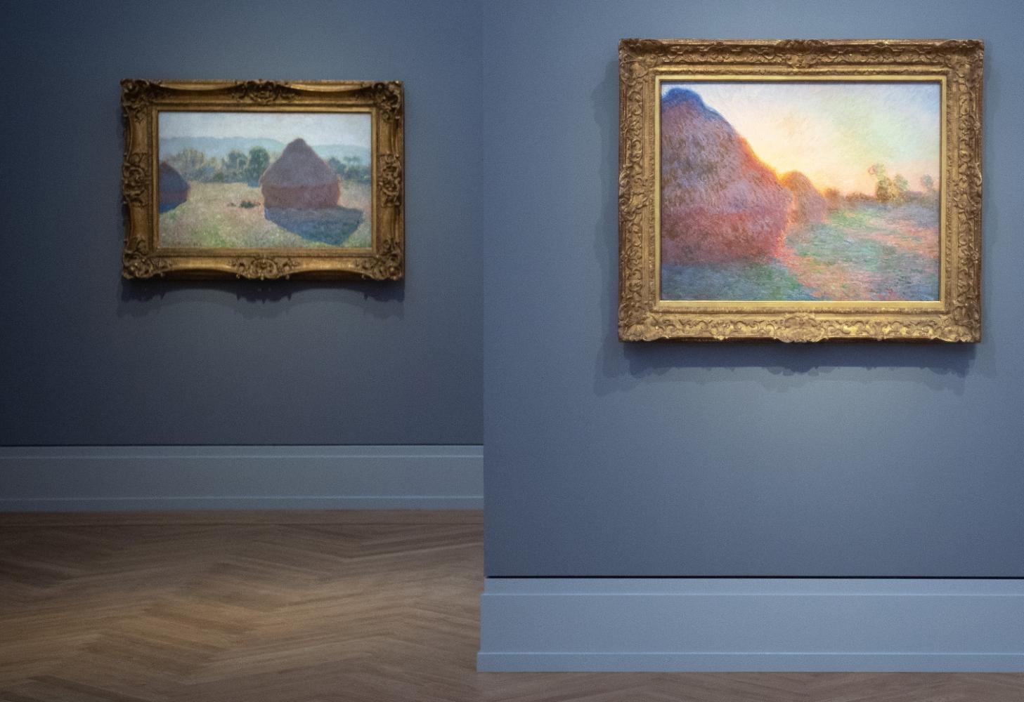 Die Gemälde "Getreideschober in der Mittagssonne" (1890, l) und "Getreideschober" (1890) in der Ausstellung "Monet.Orte" im Museum Barberini in Potsdam zu sehen