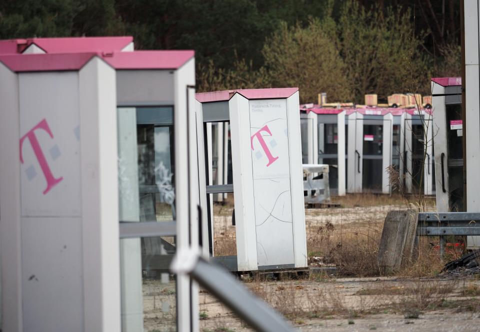 Ausrangierte Telefonzellen stehen auf einem abgezäunten Gelände in Brandenburg